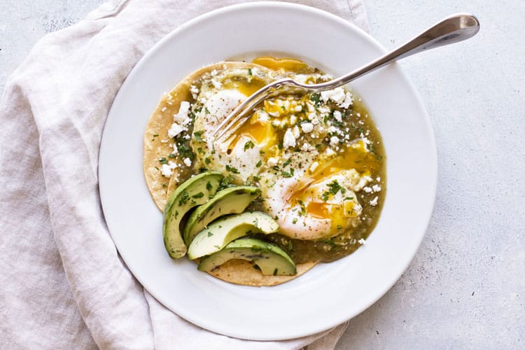 overhead photo of a plate of salsa verde eggs with a fork