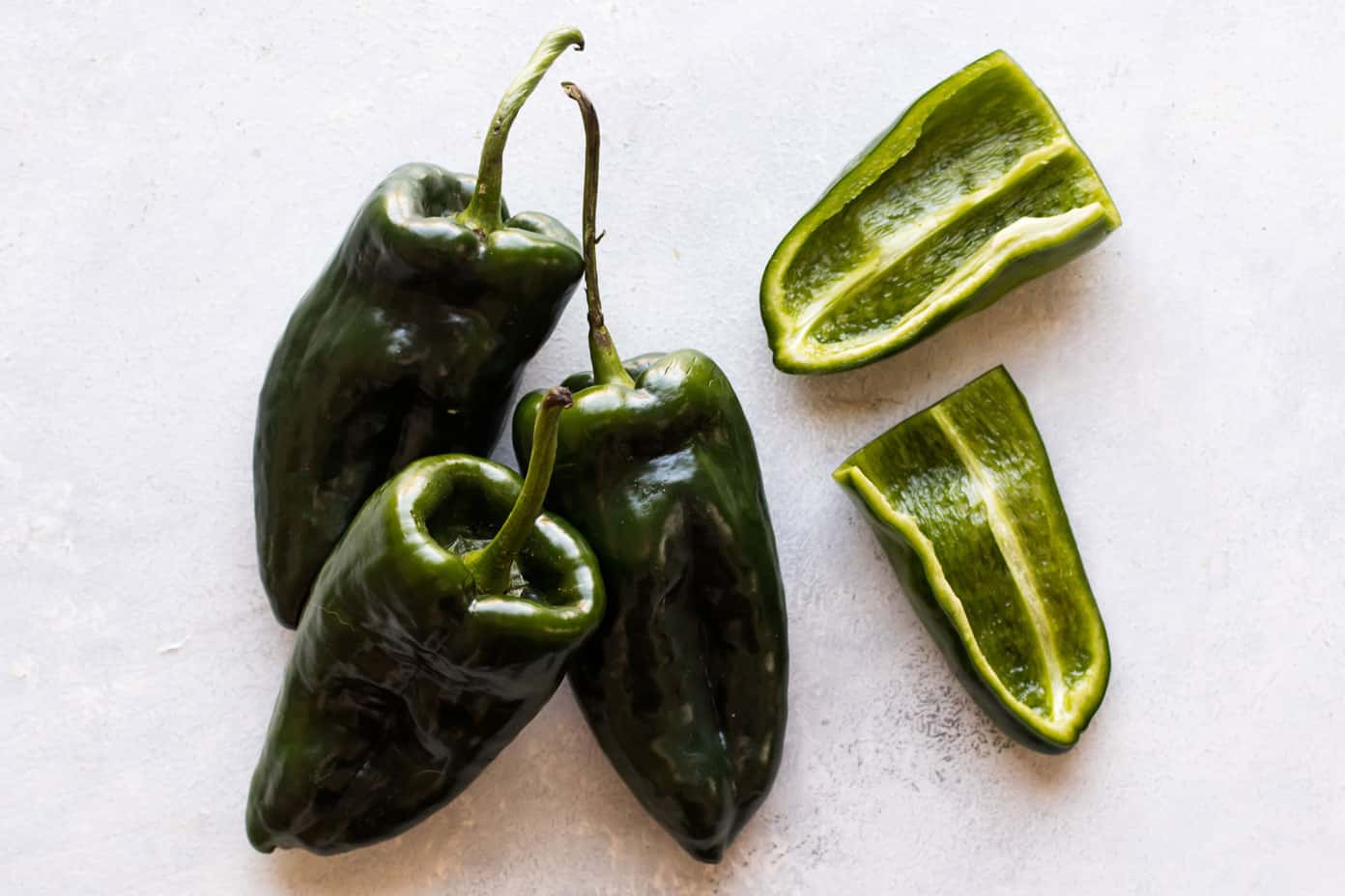 photo of three poblano peppers and one sliced in half