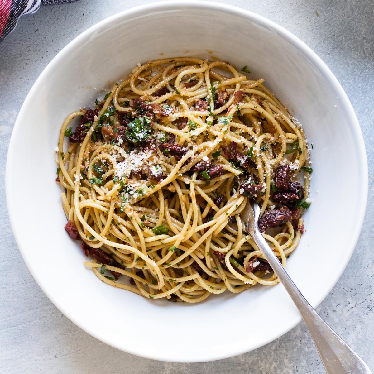 a bowl of spaghetti with tomatoes and bacon.