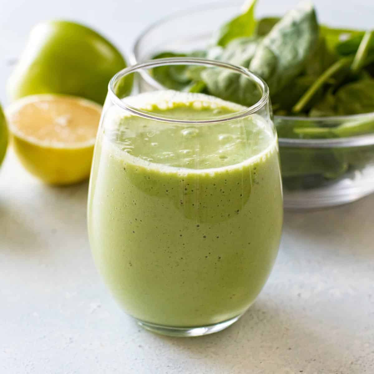 close-up photo an apple smoothie with the ingredients in the background