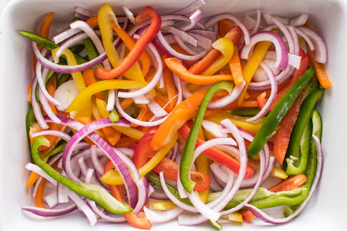 overehead photo of sliced peppers and onions mixed up together
