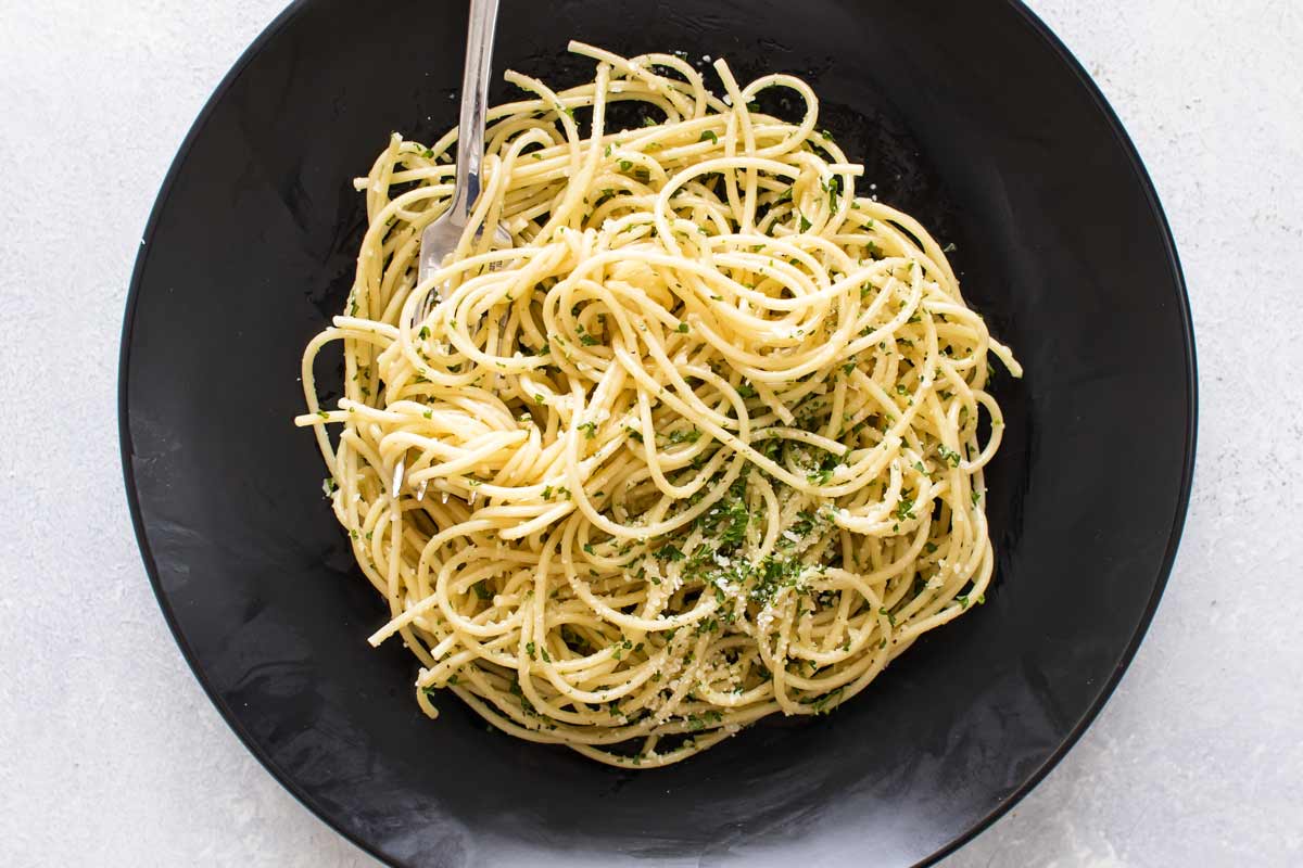 overhead photo of pasta on a black plate