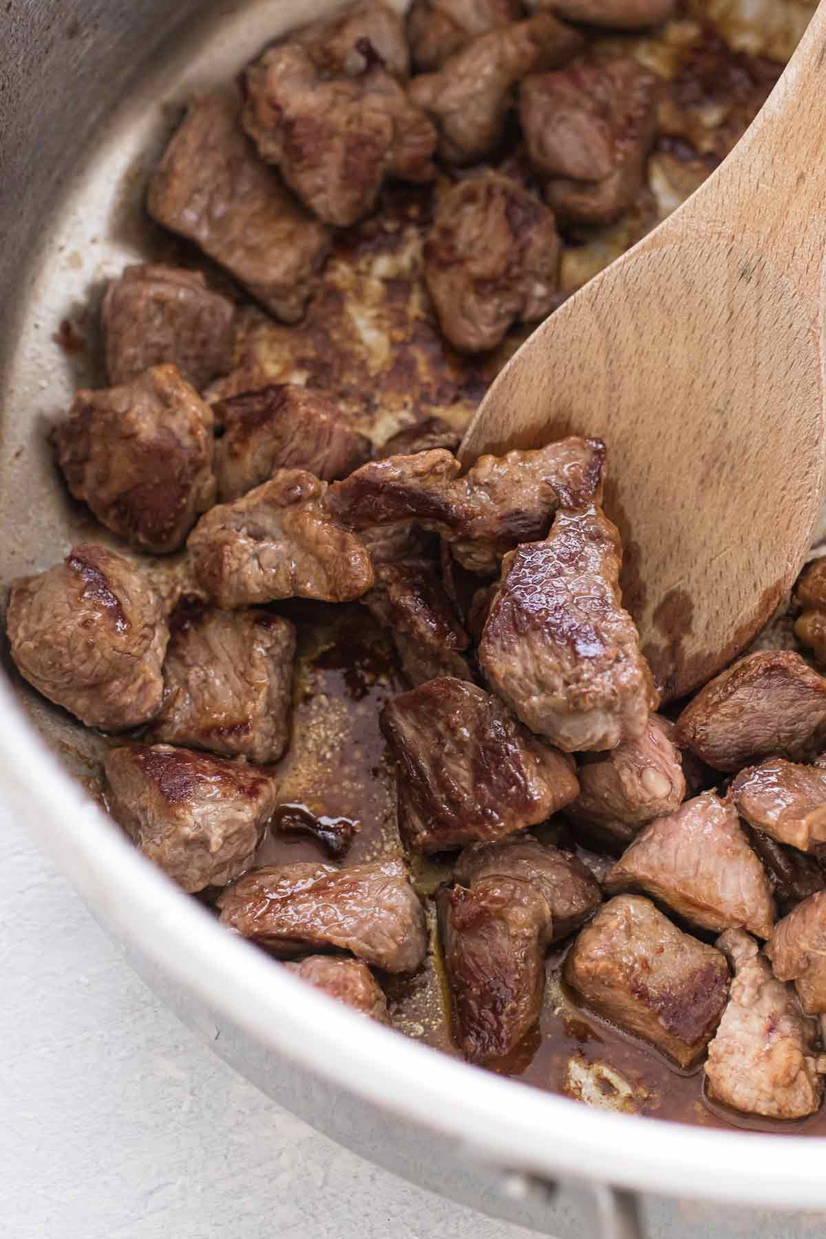 close-up photo of browned lamb in a pan.