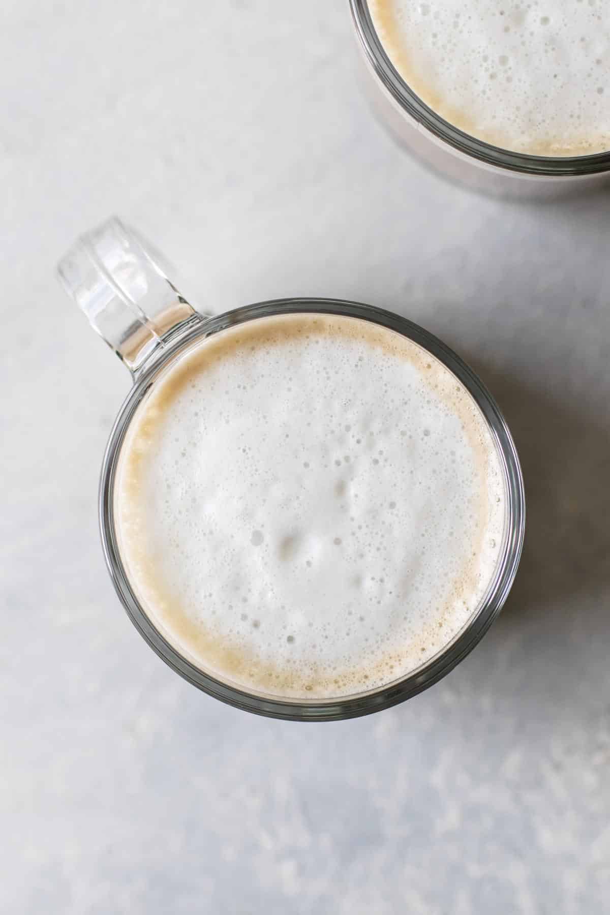 overhead photo of a mug of coffee topped with frothed milk