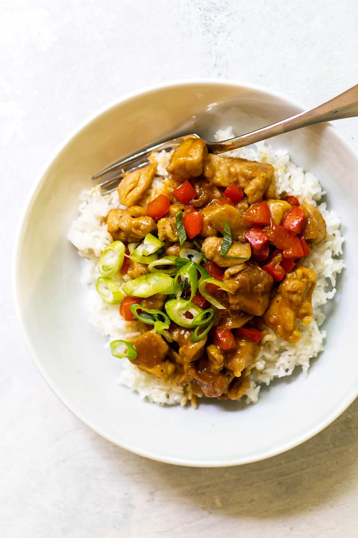 overehead photo of orange chicken in a bowl with rice