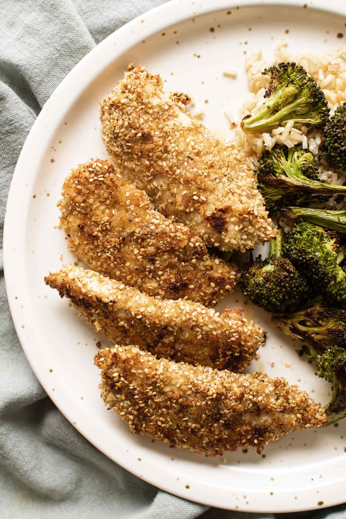 overhead photo of sesame chicken tenders on a plate with broccoli and rice