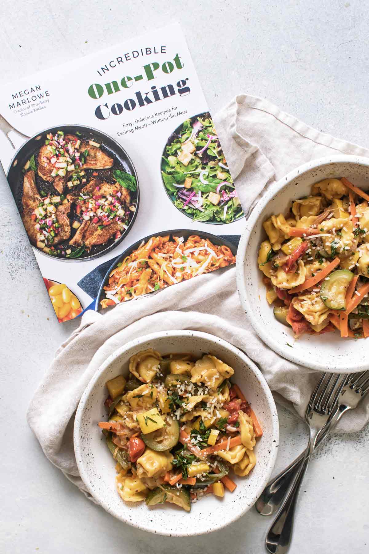 overhead photo of the cookbook with two bowls of pasta