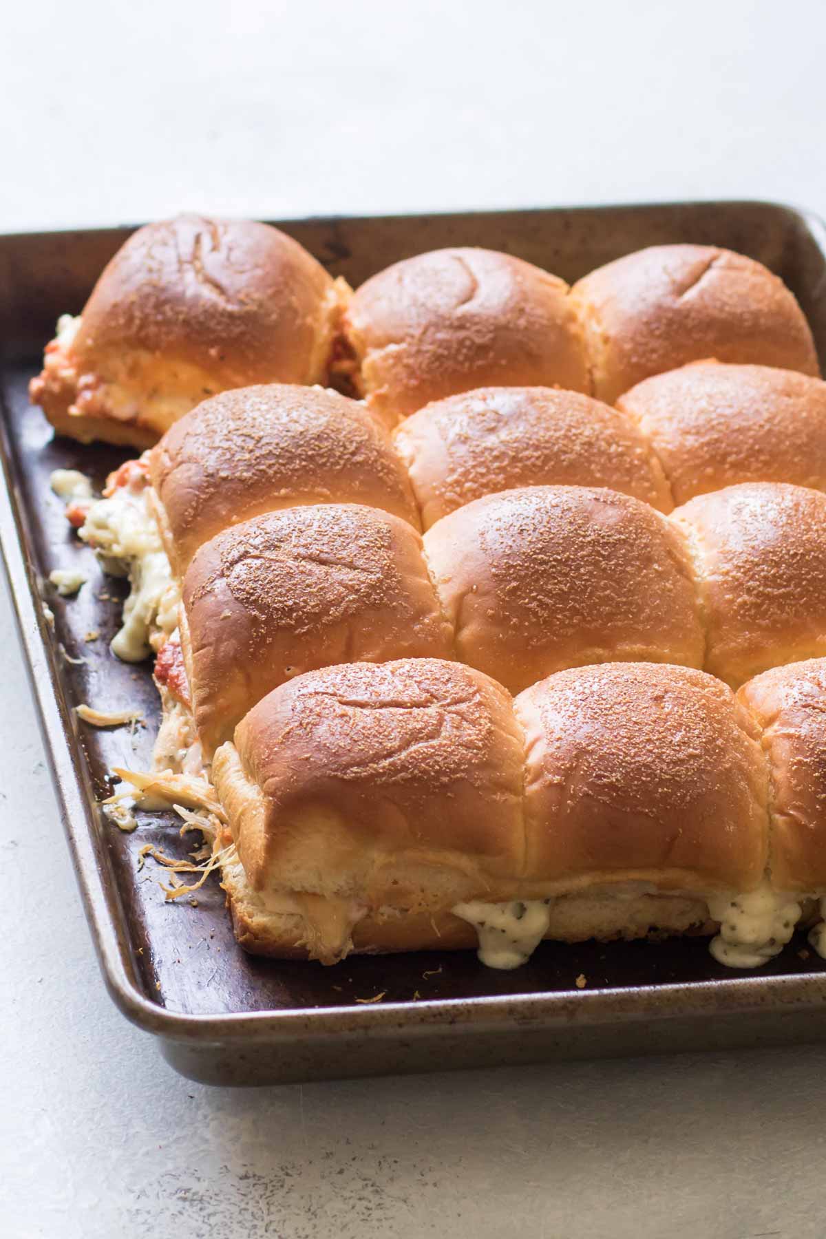 baked chicken sliders on a baking sheet.