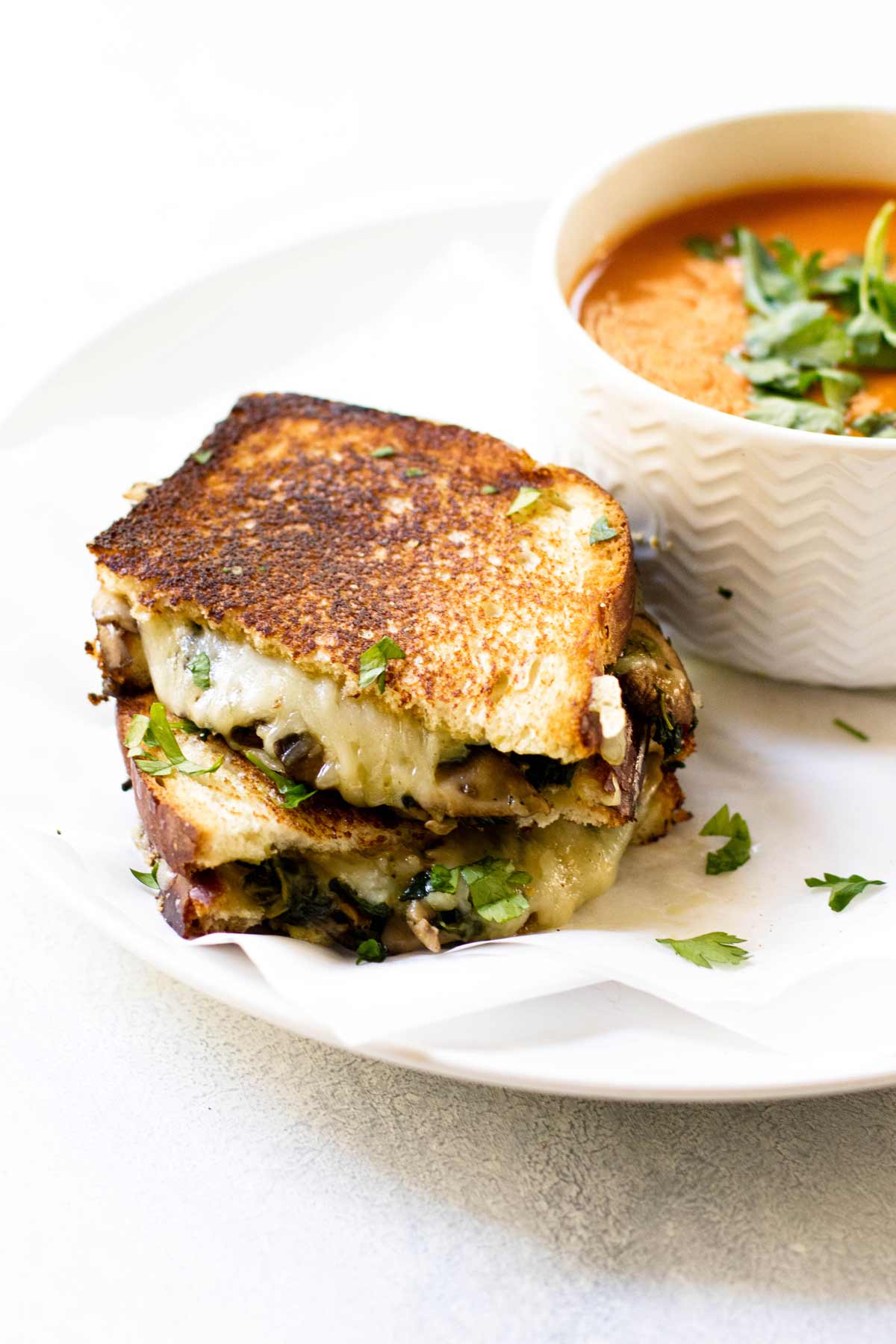 a sandwich on a plate with a bowl of soup.