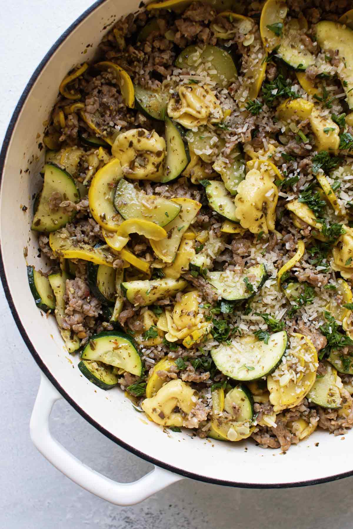 pasta, tortellini, and squash with pesto in a pan.