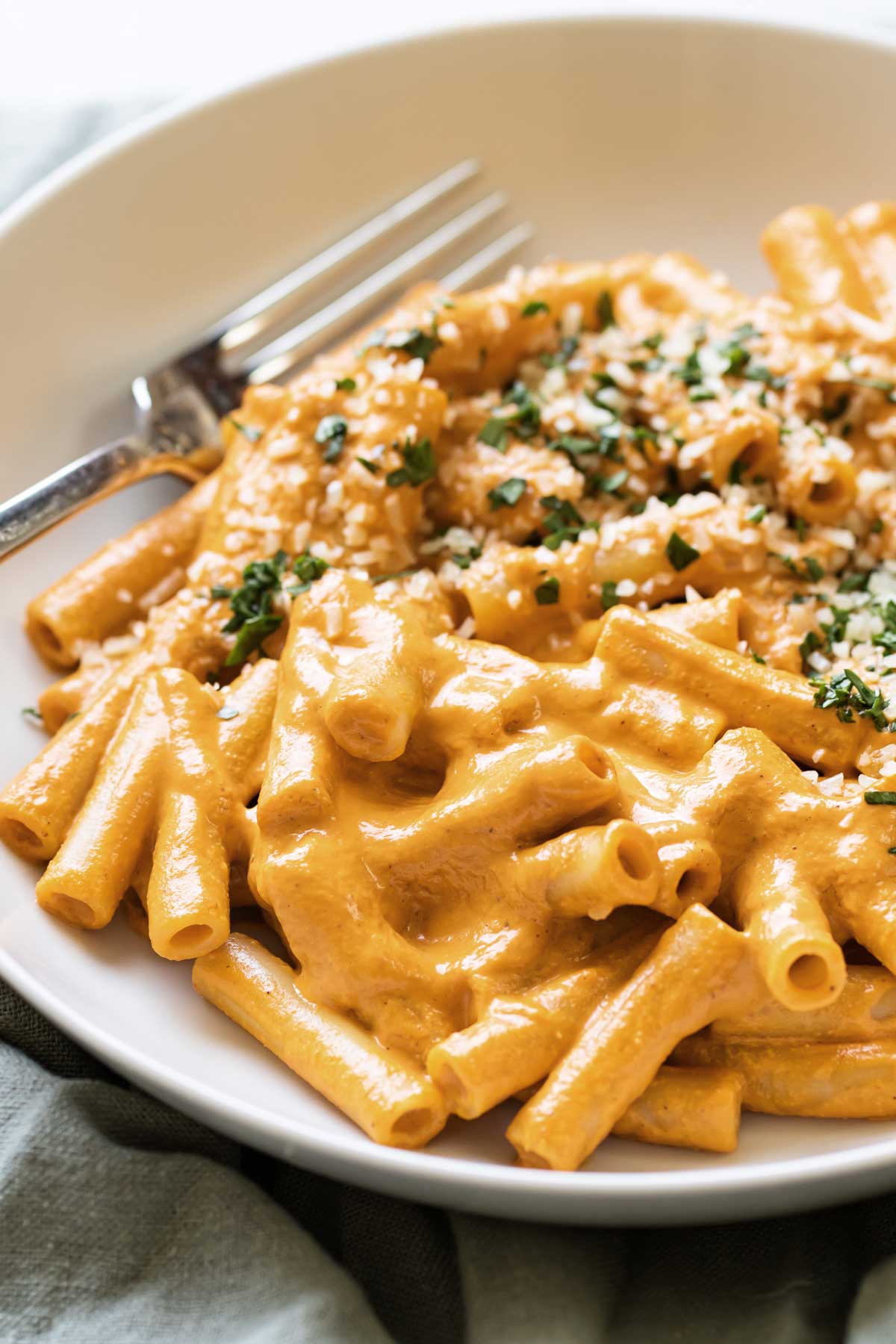 pasta coated in roasted red pepper sauce in a bowl