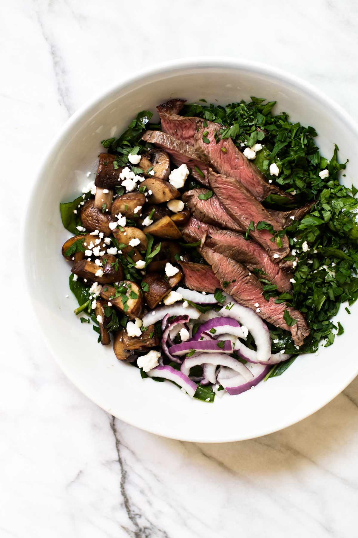 steak salad with mushrooms in a bowl.