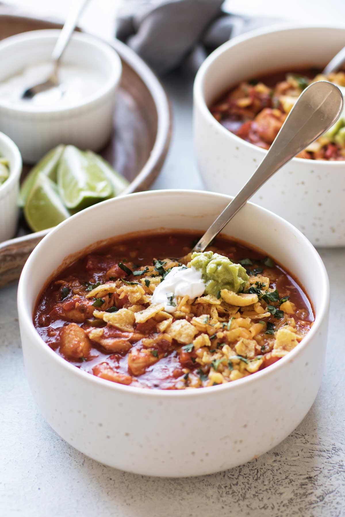 a bowl of chicken chili with toppings