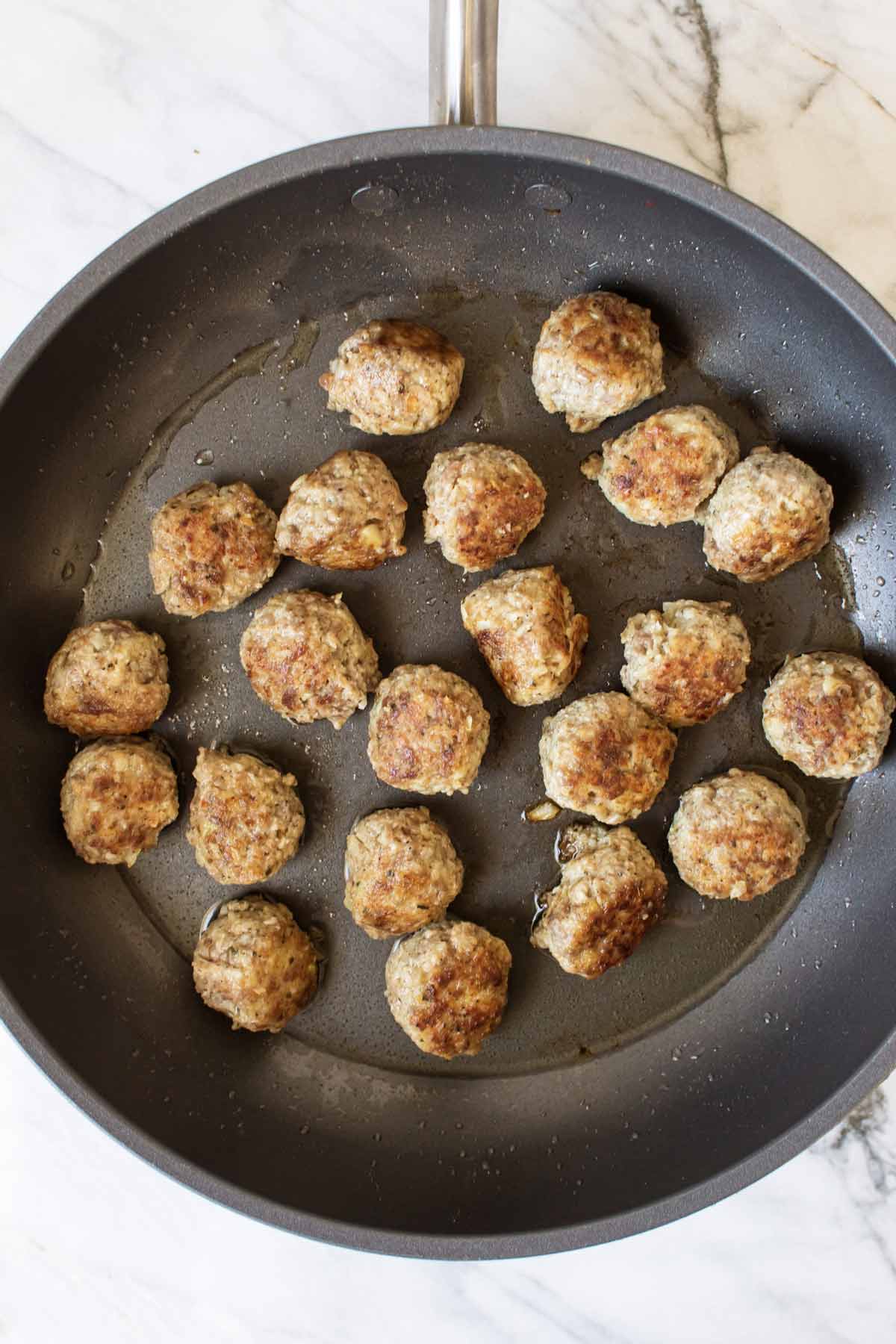 meatballs browning in a pan