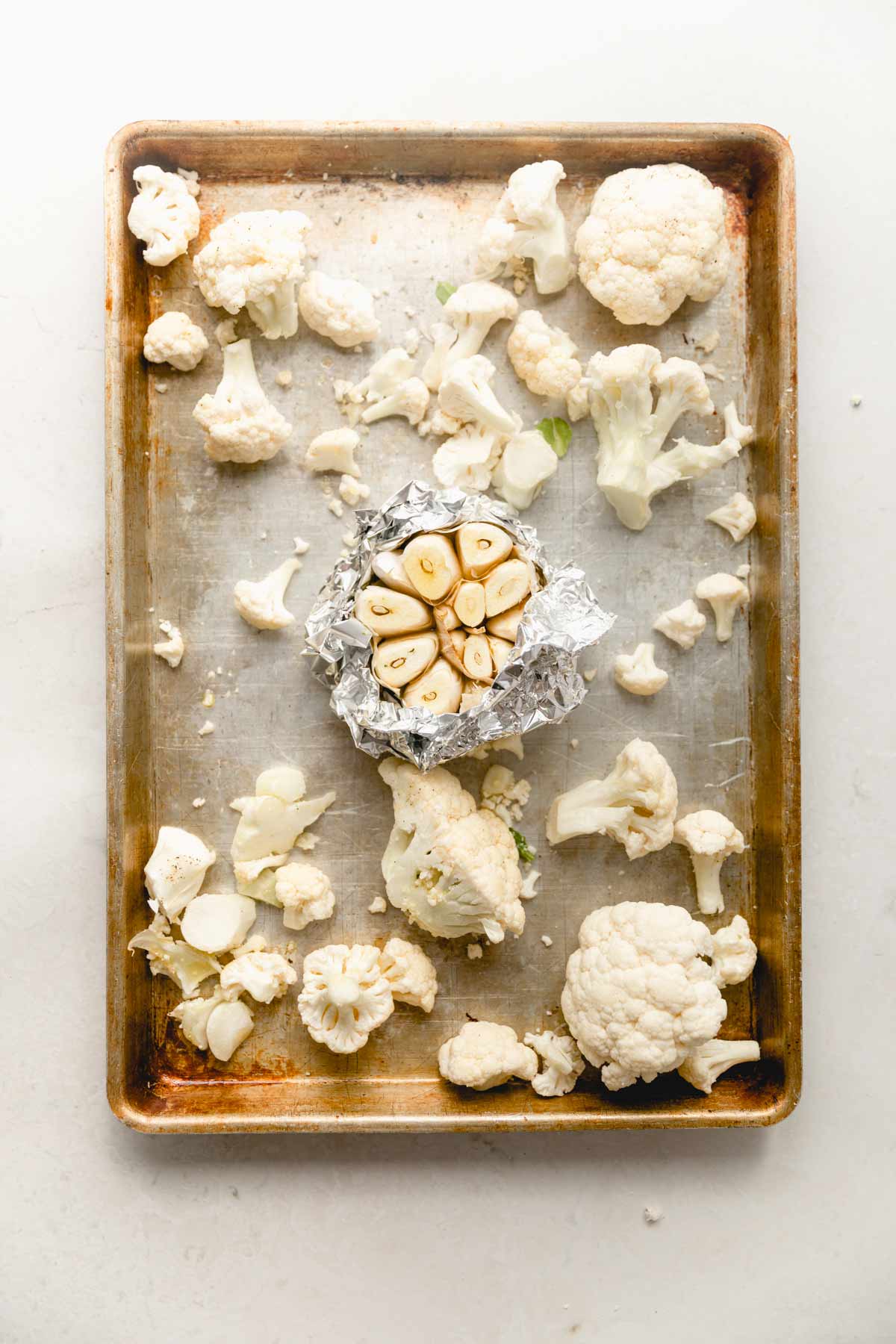 cauliflower and garlic on a sheet pan.