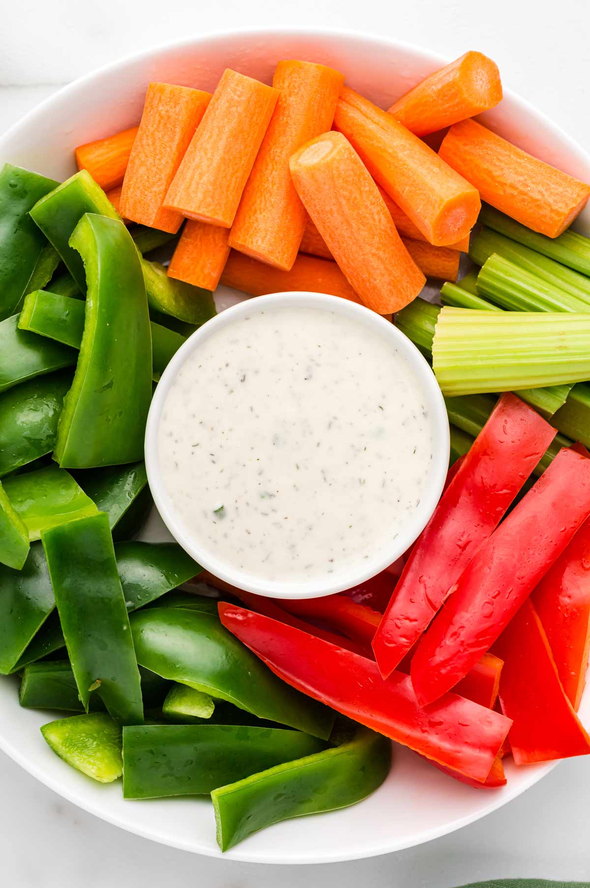 ranch dressing in a bowl on a platter with fresh vegetables
