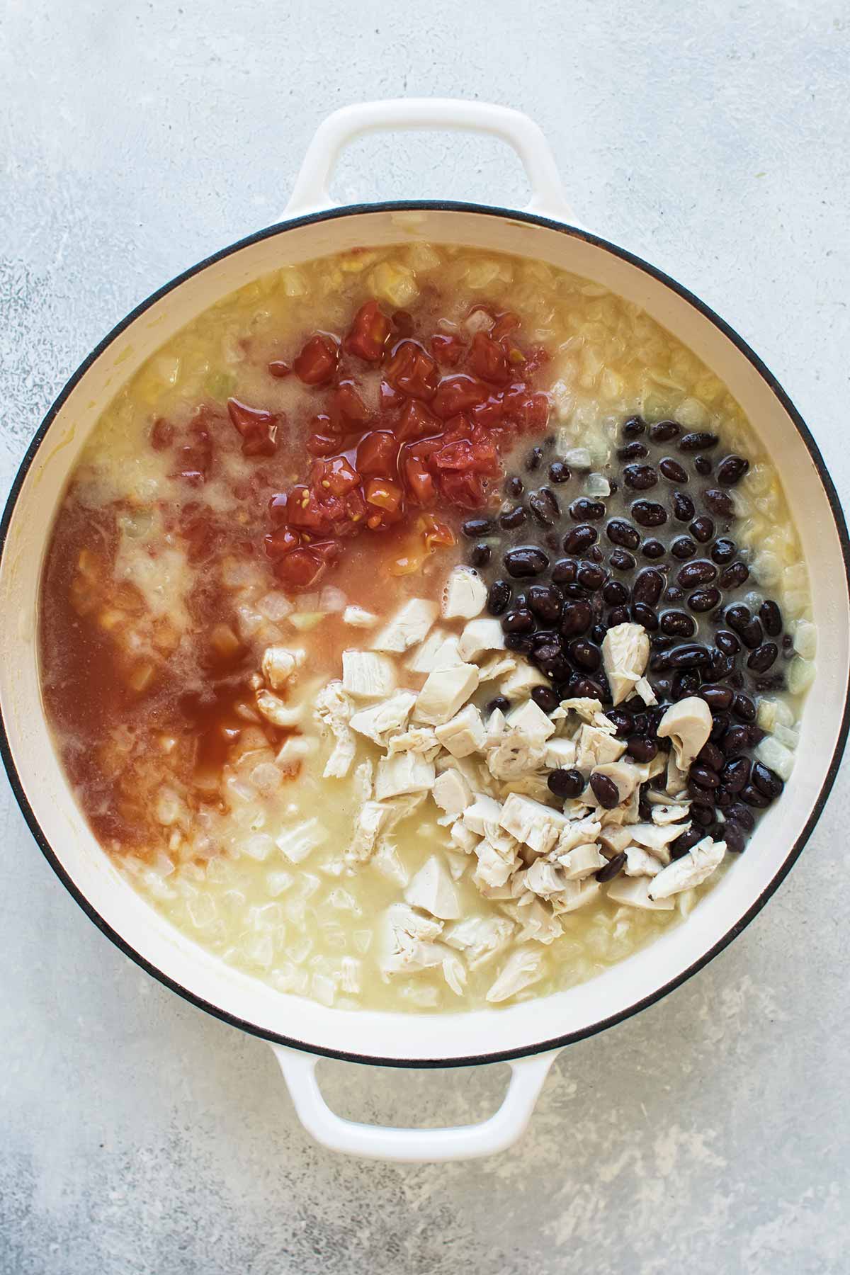 beans, tomatoes, broth, and chicken added to the pot.