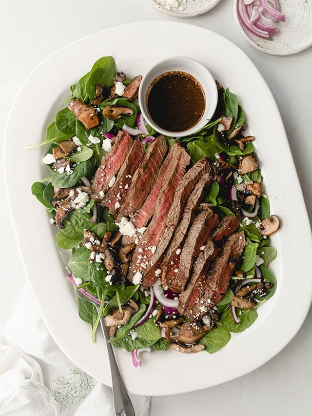 steak salad with dressing.