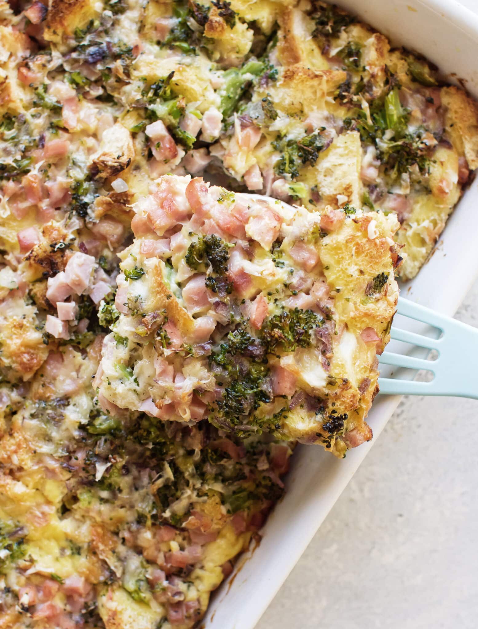 a slice of breakfast strata being lifted from the pan.