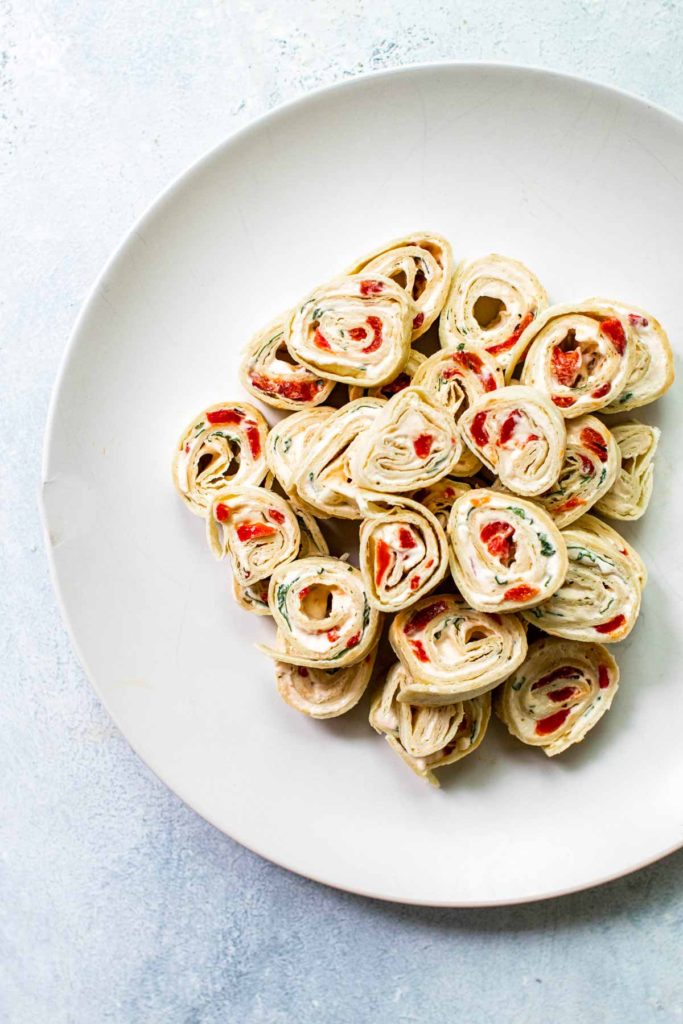 a stack of tortilla pinwheels on a white plate.