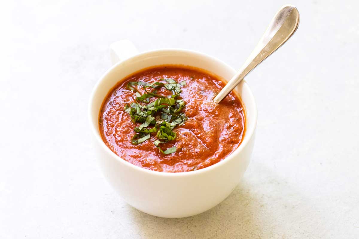 tomato basil soup in a white soup mug.