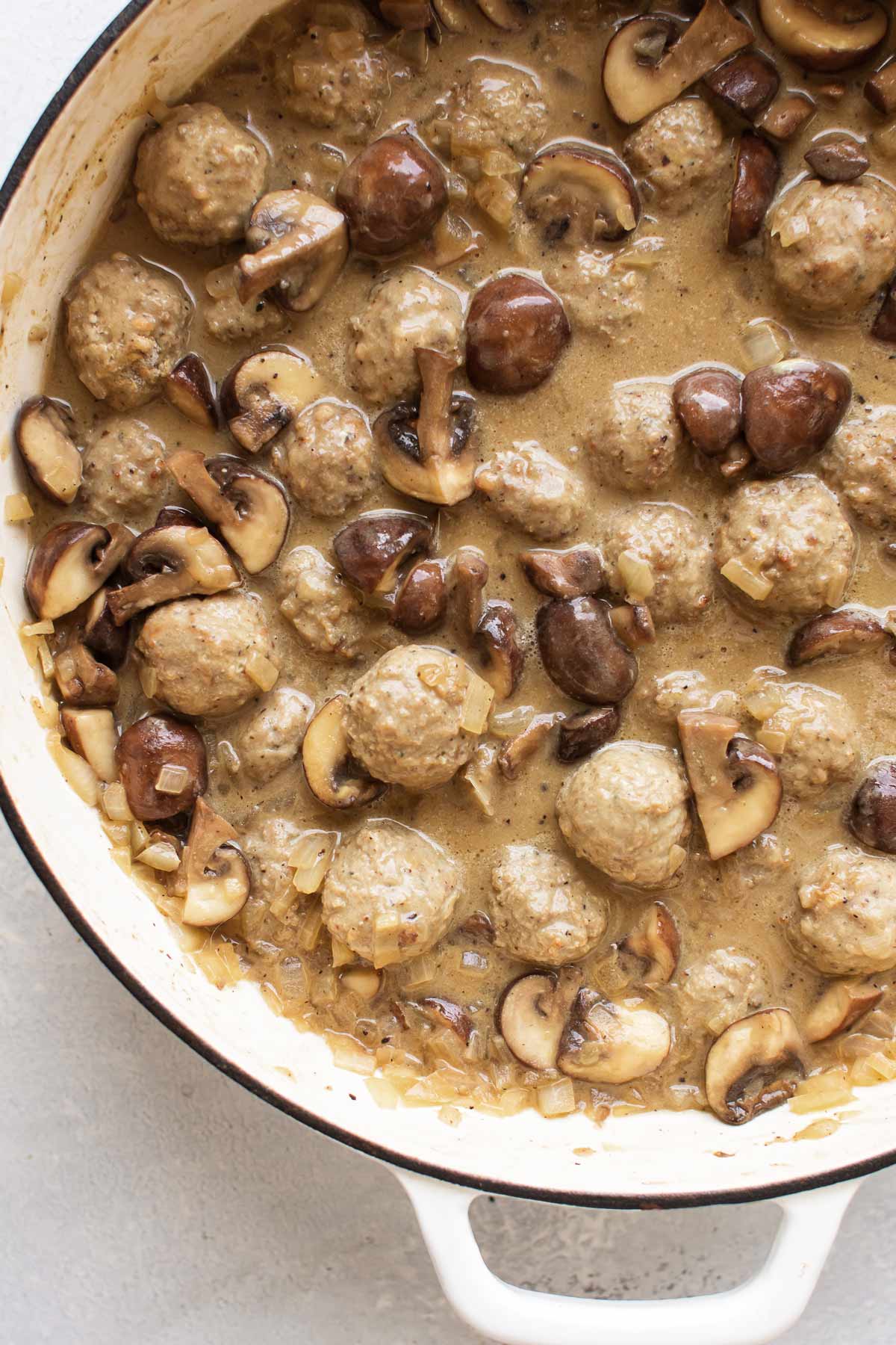 meatballs and mushrooms simmering in a sauce