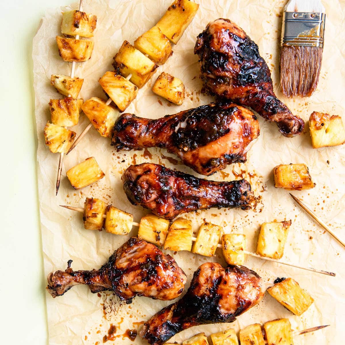 overhead shot of grilled drumsticks with grilled pineapple.