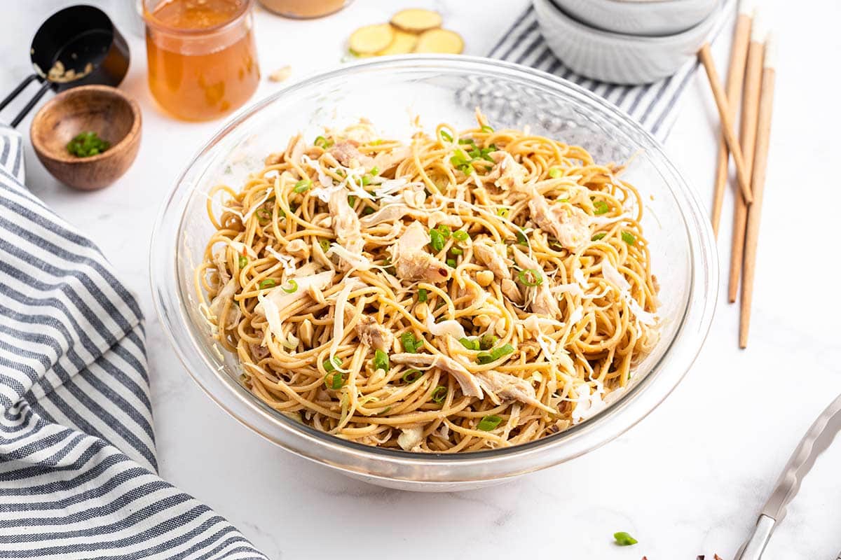 sesame noodles with chicken in a bowl.