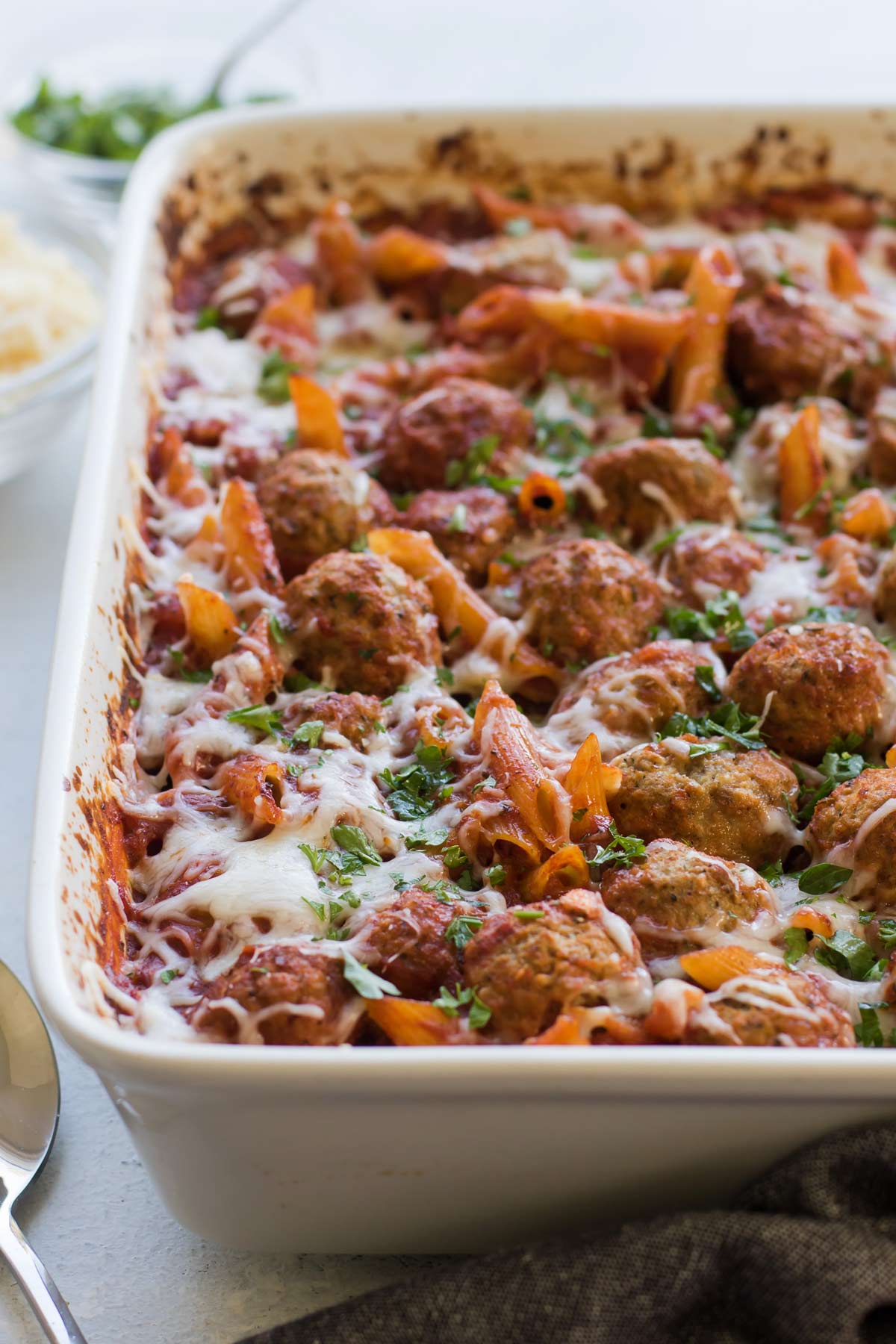 baked penne and meatballs in a baking dish.