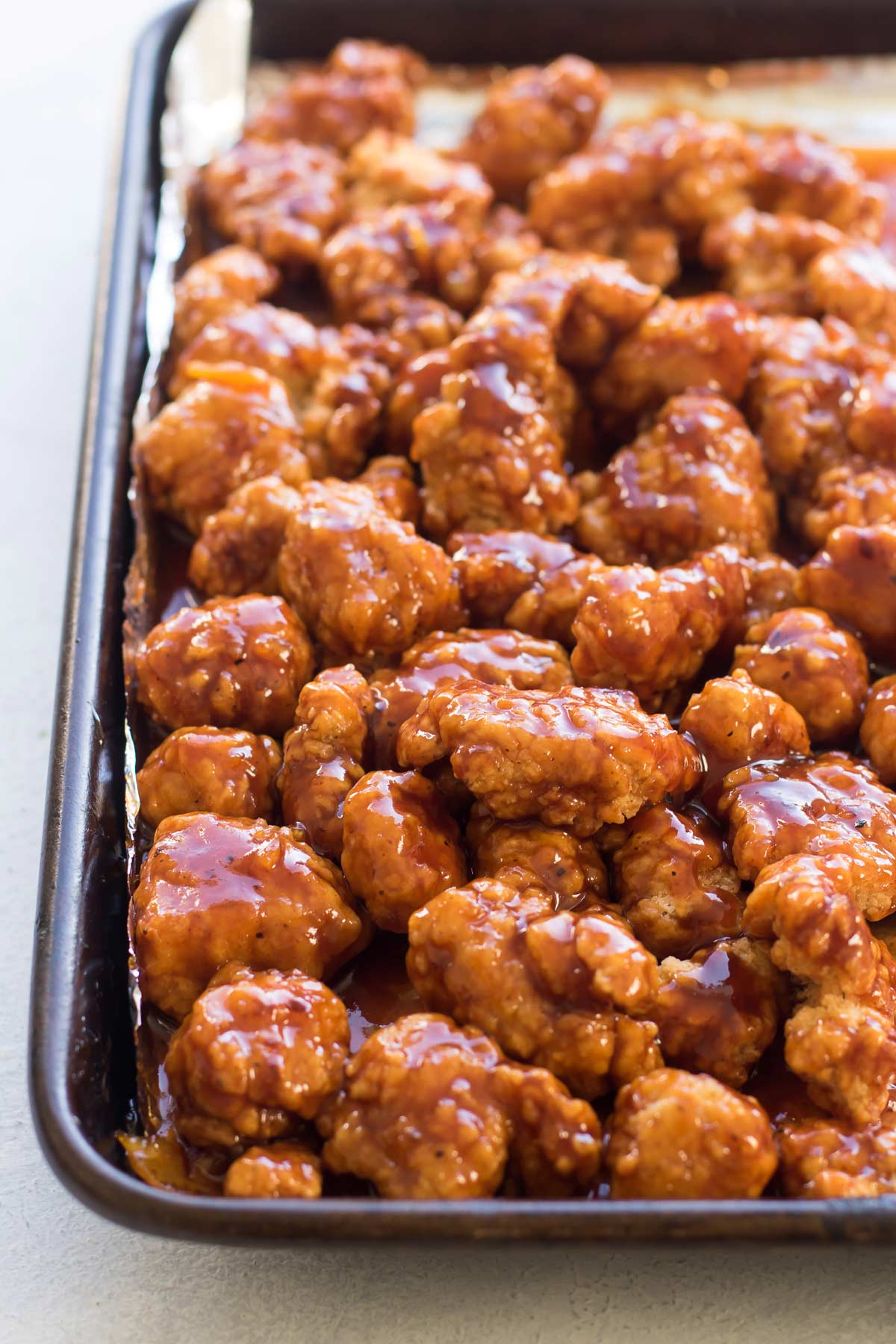 orange chicken on a sheet pan.