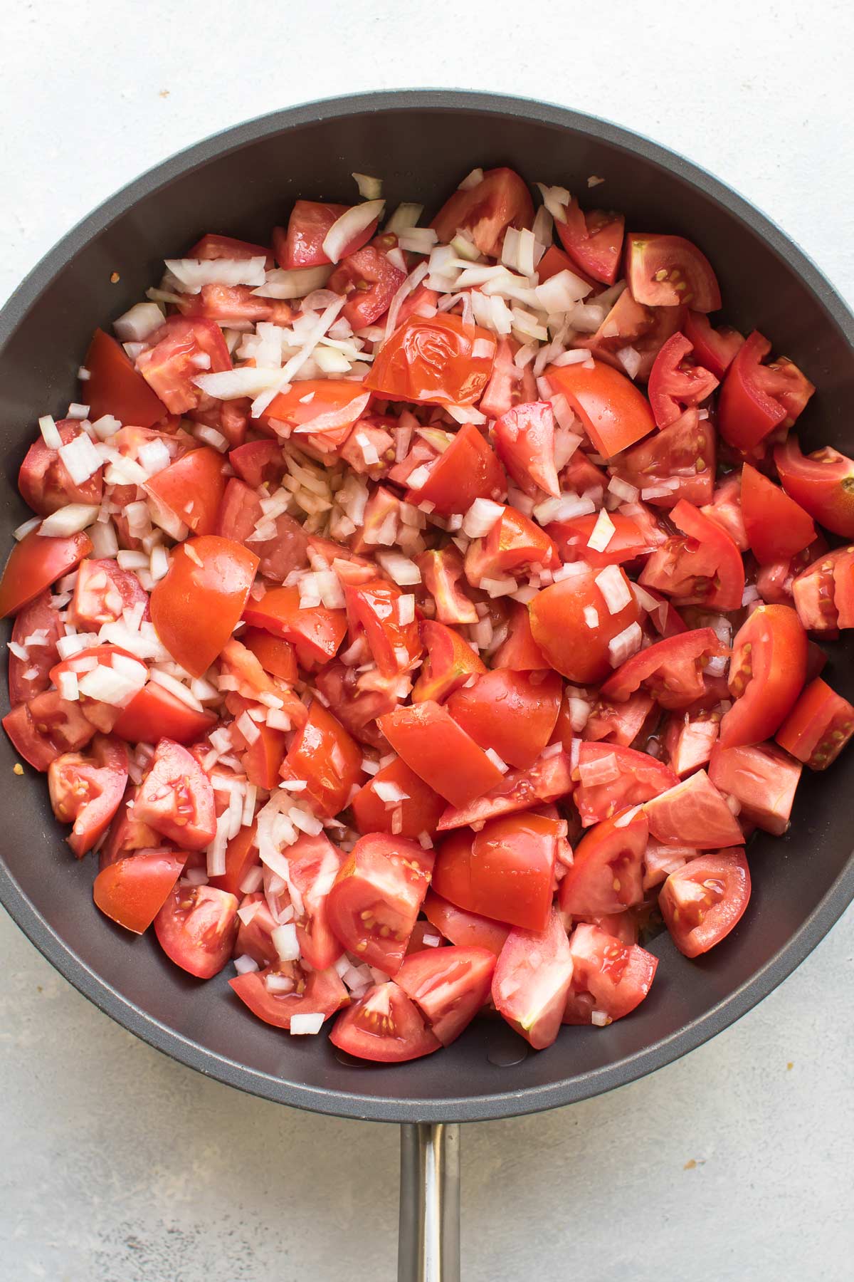 tomatoes and onions in a pan.