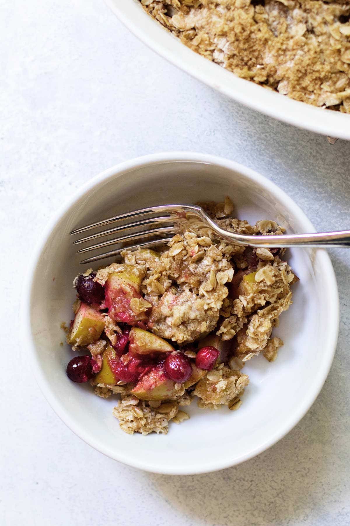 a bowl with a serving of cranberry apple crisp.