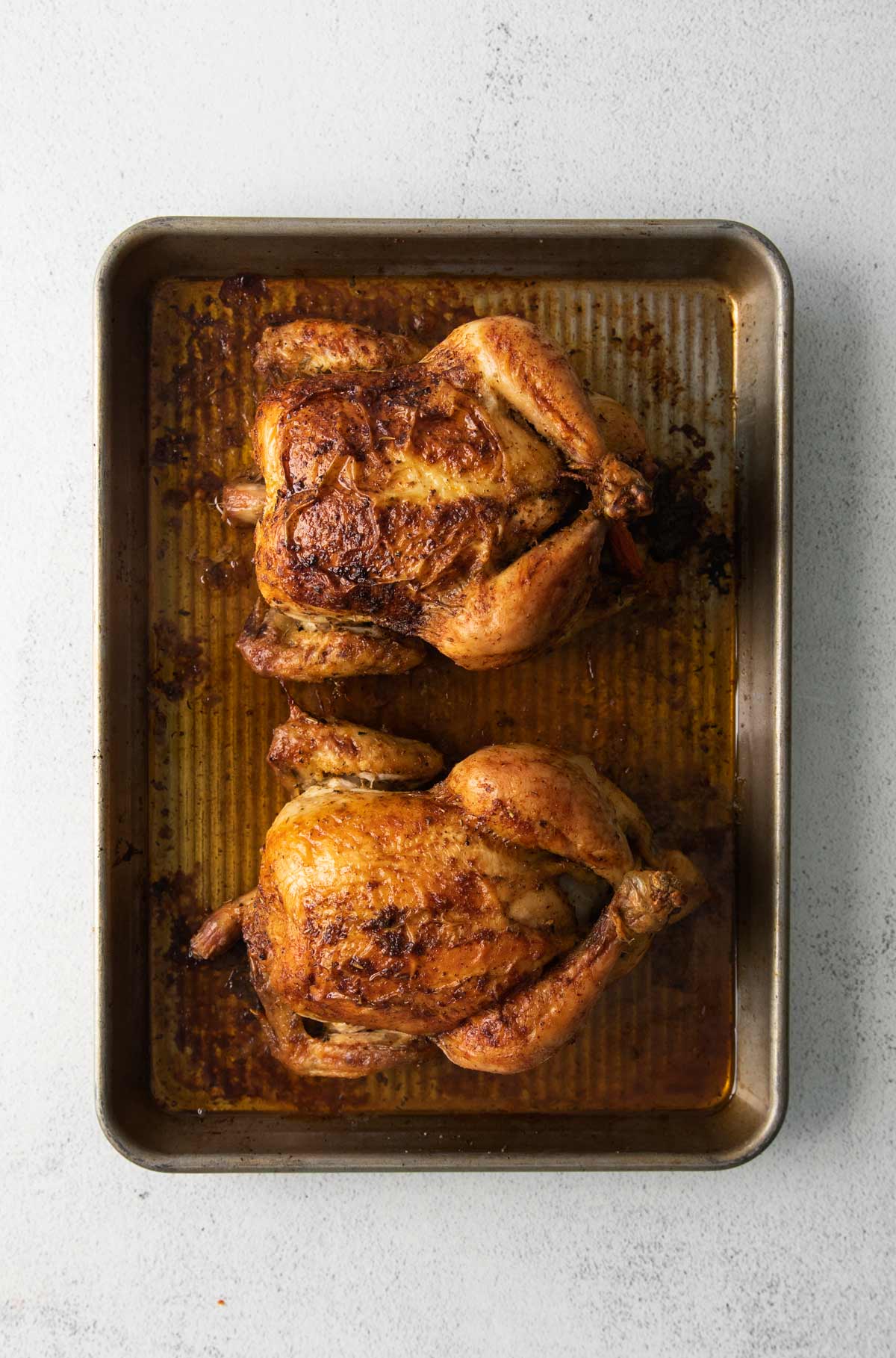 roasted hens on a baking sheet.