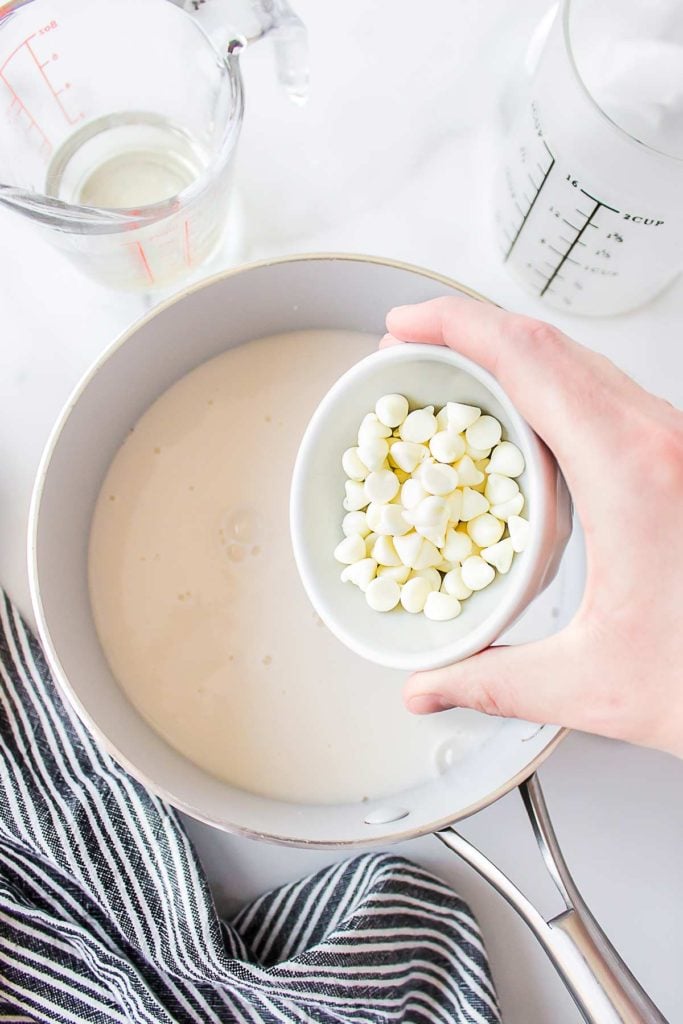 white chocolate chips being added to the warm milk.