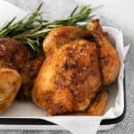 roasted cornish game hen in a pan.