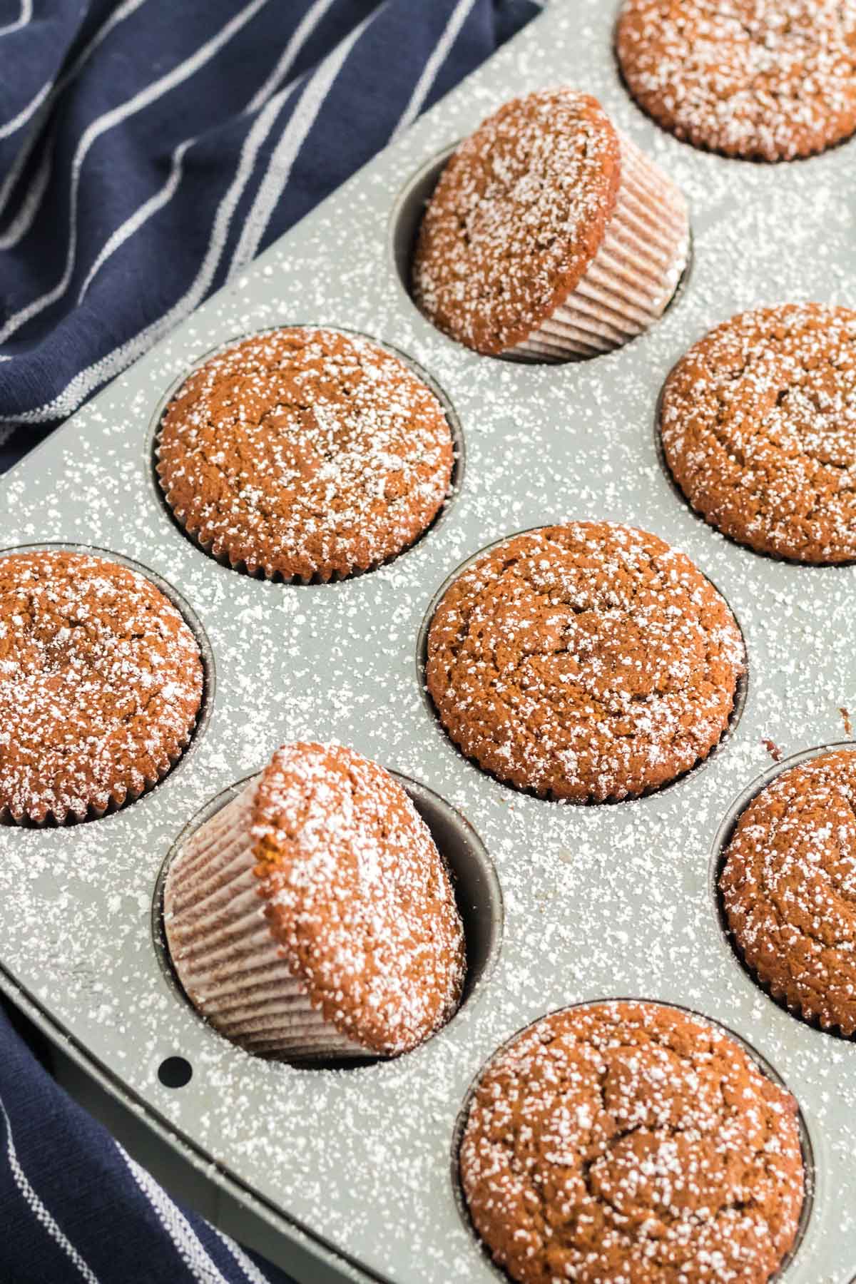 gingerbread muffins in the pan dusted with powdered sugar.