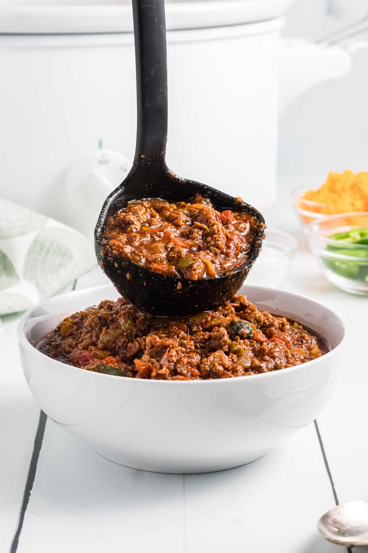 chili being ladled into a bowl.