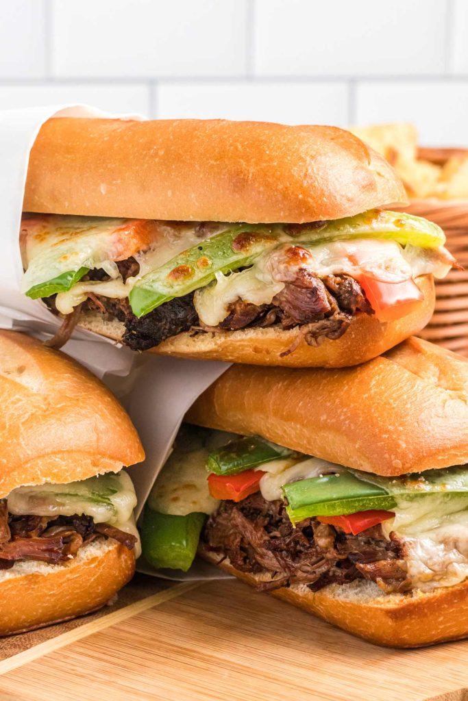 shredded beef sandwiches stacked on top of each other.