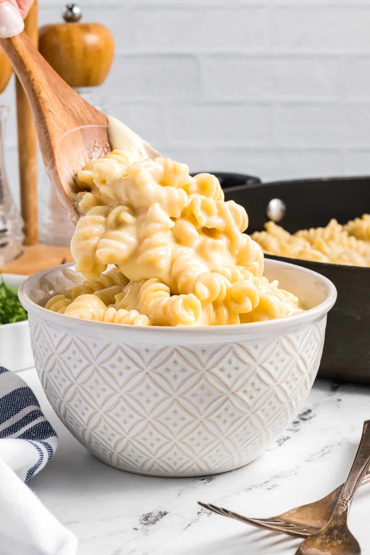 mac and cheese being spooned in a a bowl.