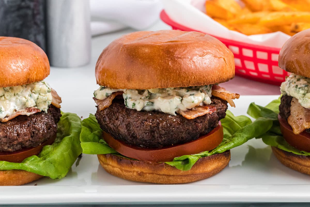 burgers lined up on a plate.
