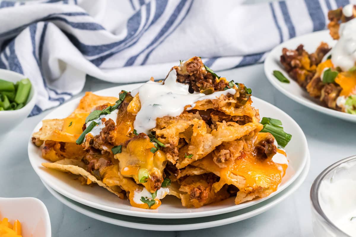a serving of nachos on a white plate.
