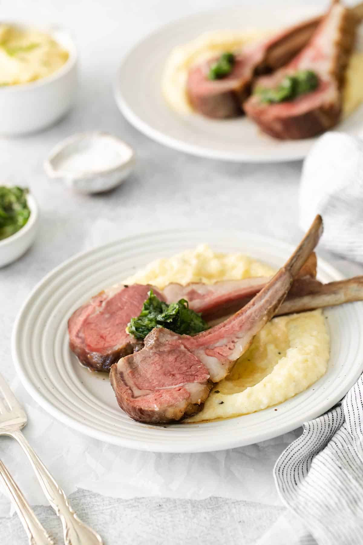 lamb chops on a plate with mashed potatoes.