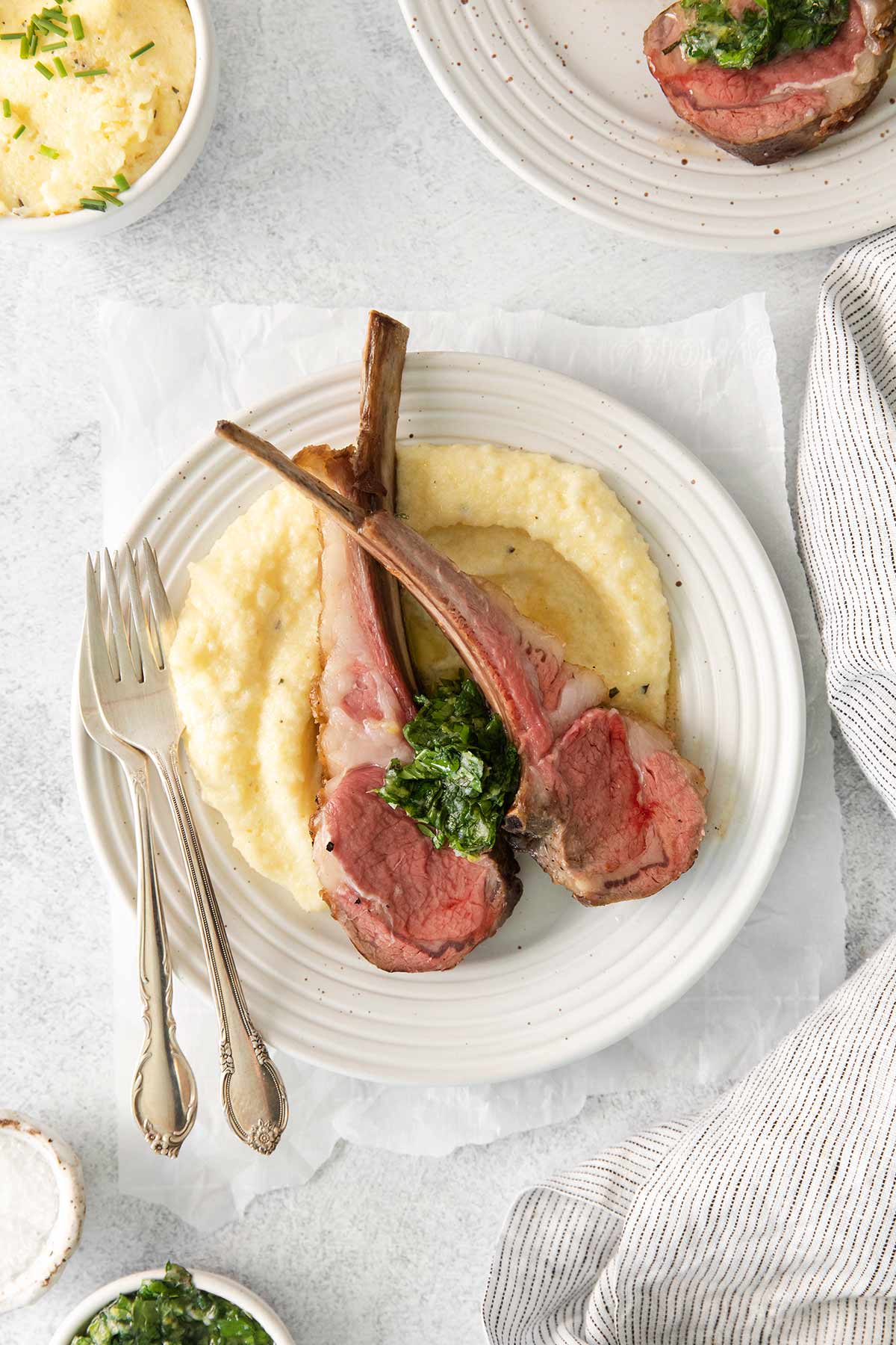 overhead shot of lamb chops on a plate with mashed potatoes.
