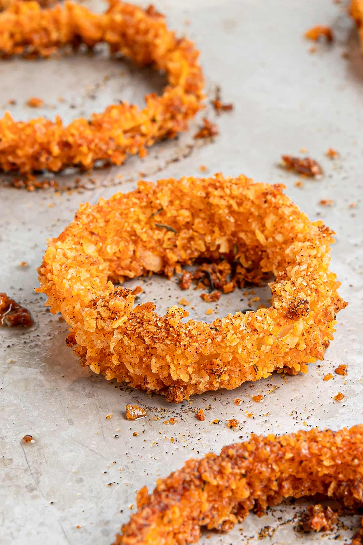 close-up shot of a baked onion ring on a sheet pan.
