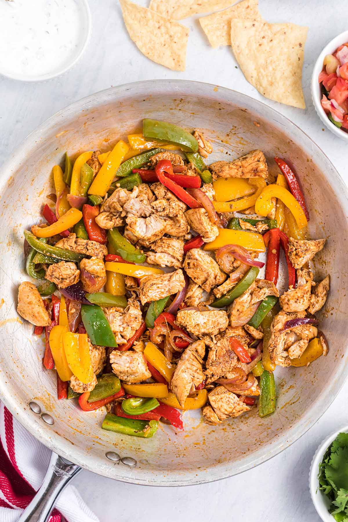 overhead shot of the chicken and peppers in a skillet.