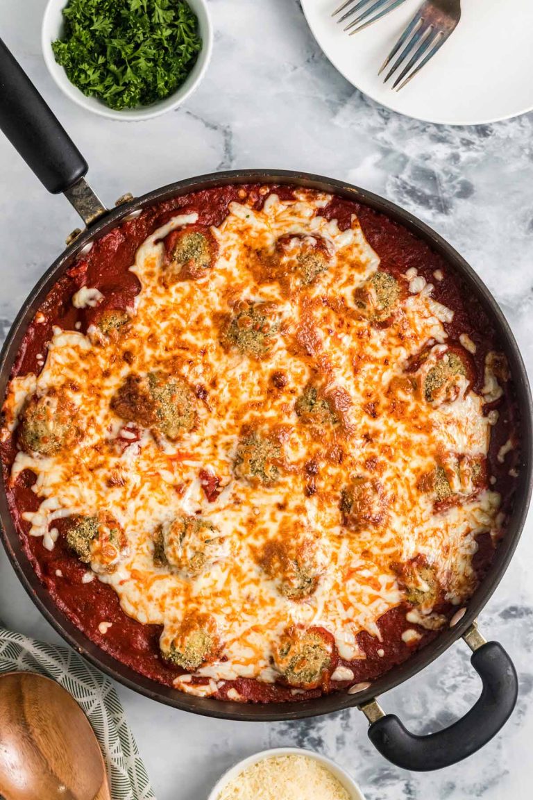 overhead shot of the meatballs, sauce, and cheese in a skillet.