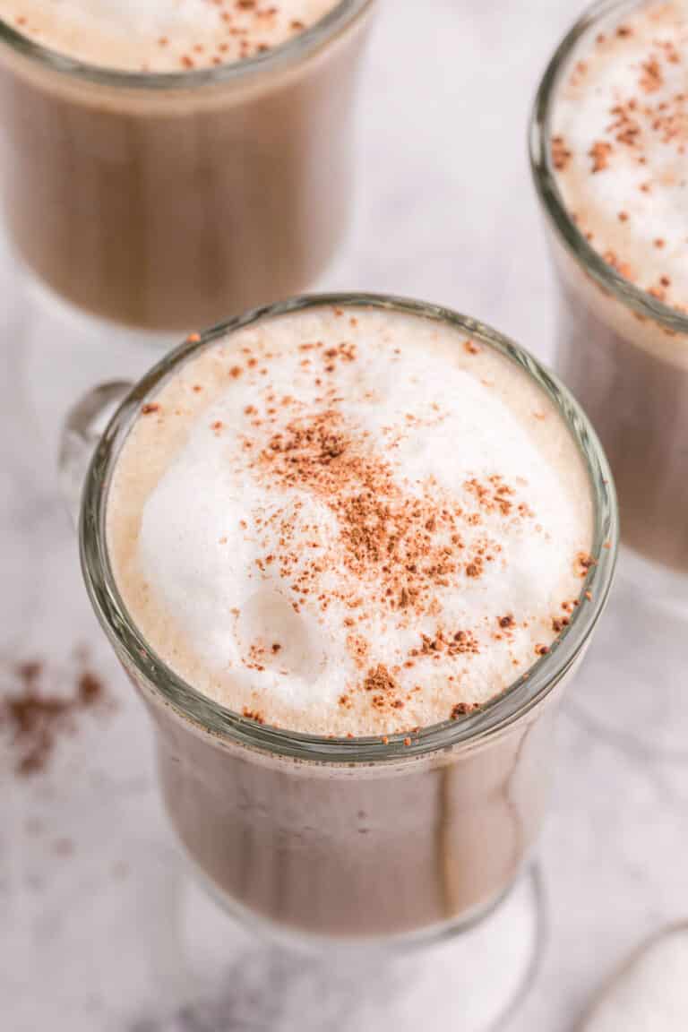 overhead shot of a cup of coffee topped with frothed milk.