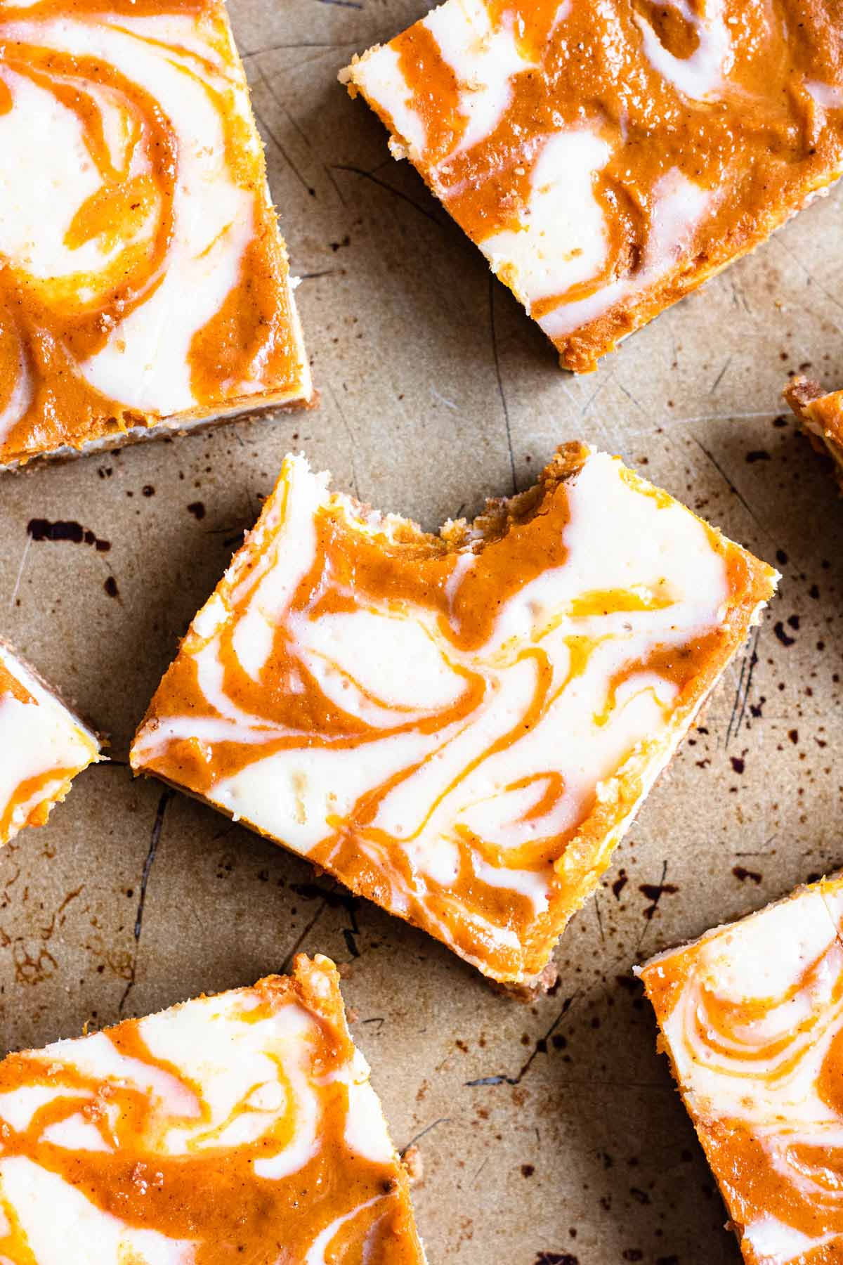 a pumpkin cheesecake bar with a bite taken out of it.