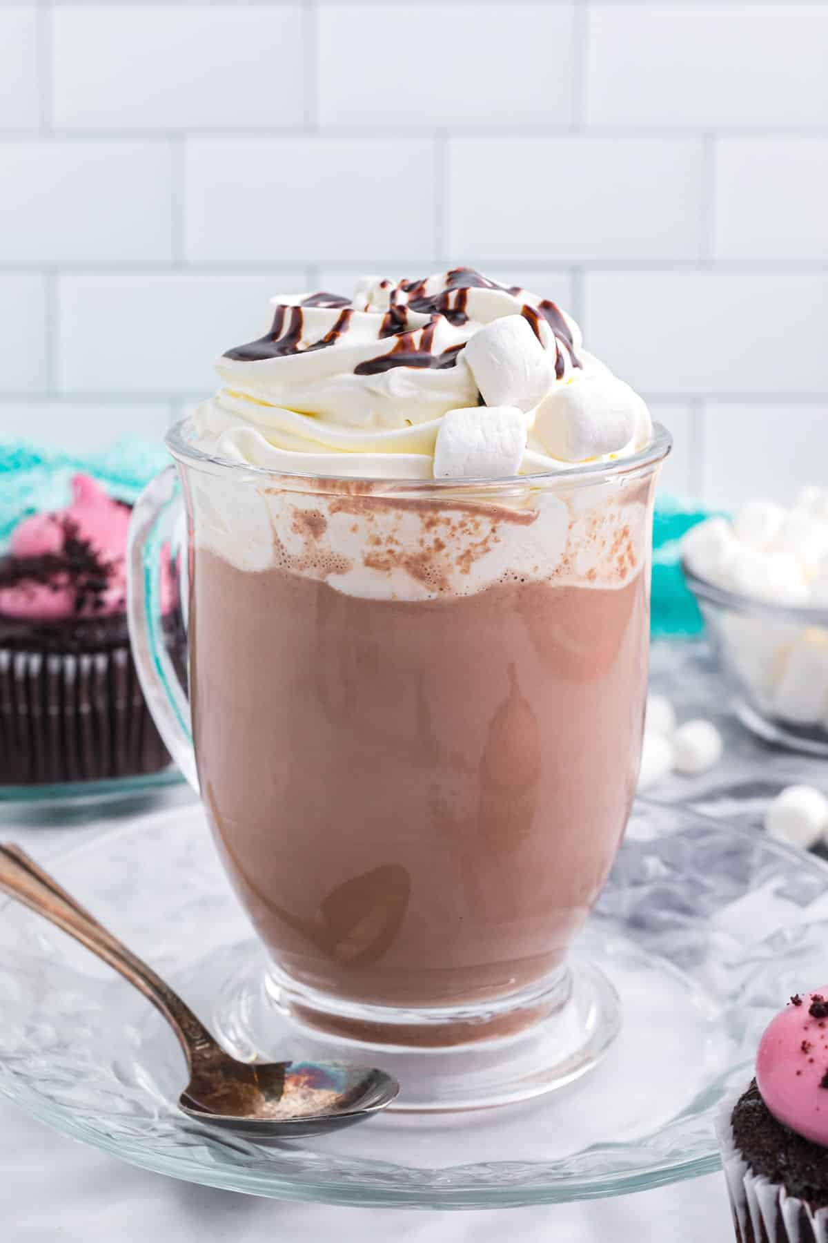 a mug of hot cocoa topped with whipped cream and a drizzle of chocolate.