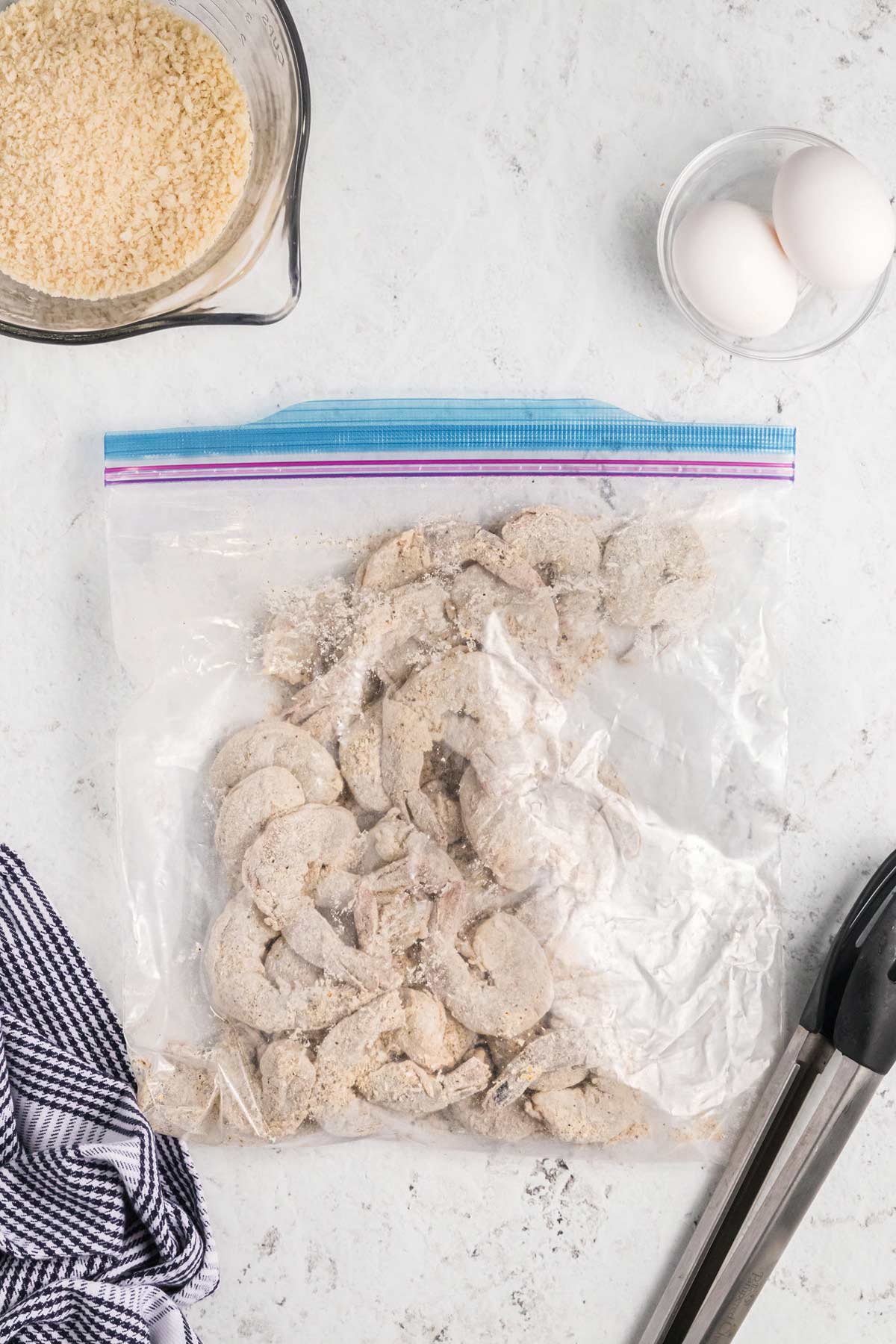 raw shrimp in a bag with the seasoned flour.